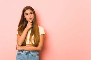 Sıska bir kadın şüpheli ve şüpheci bir ifadeyle yana bakıyor..