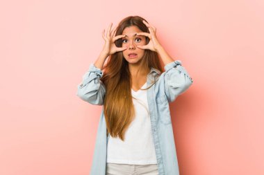 Young slim woman keeping eyes opened to find a success opportunity.