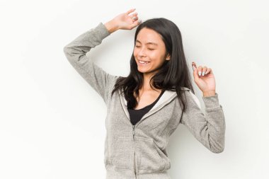 Genç fitness Çinli kadın özel bir günü kutluyor, atlıyor ve enerji ile kollarını kaldırıyor..