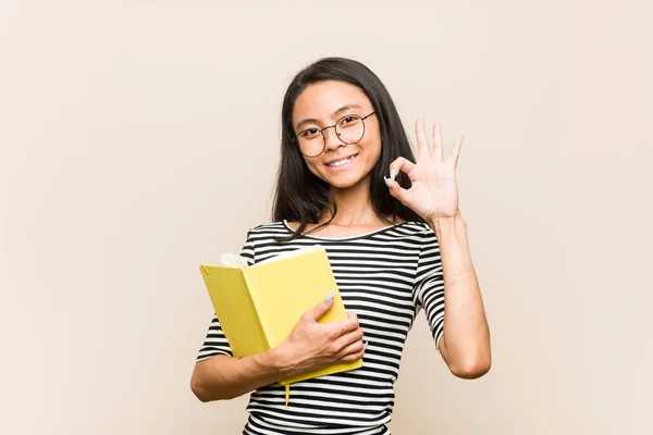 Junge Asiatische Studentin Hält Ein Buch Fröhlich Und Zuversichtlich Zeigt — Stockfoto