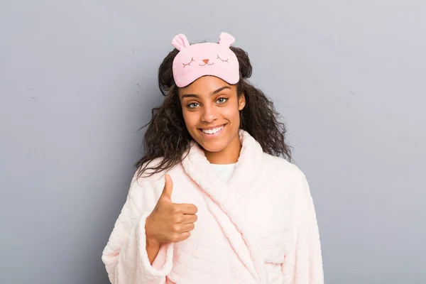 身穿睡衣和睡眠面具的年轻非洲裔美国女人微笑着举起大拇指 — 图库照片
