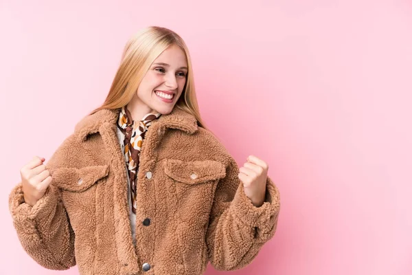 Mujer Rubia Joven Usando Abrigo Sobre Fondo Rosa Levantando Puño —  Fotos de Stock