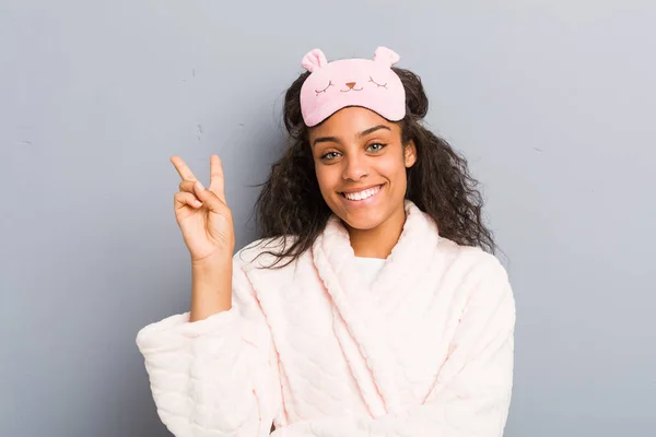 年轻的非洲裔美国女人 身穿睡衣 头戴睡眠面罩 手指是二号人物 — 图库照片