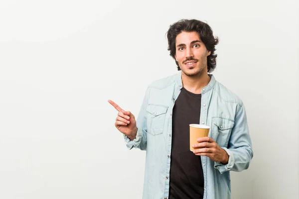 Joven Hombre Fresco Bebiendo Café Sonriendo Señalando Lado Mostrando Algo — Foto de Stock