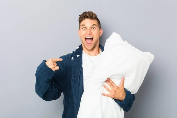 Young Man Wearing Pijama Holding Pillow Surprised Pointing Himself Smiling — ストック写真
