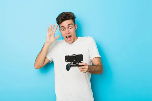 Jovem Caucasiano Jogando Videogames Com Telefone Celebrando Uma Vitória Sucesso — Fotografia de Stock