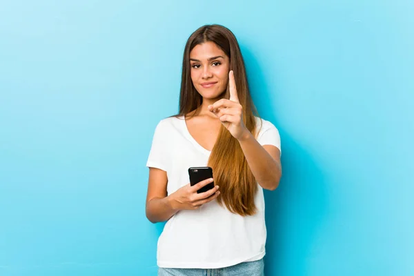 Jovem Caucasiana Segurando Telefone Mostrando Número Com Dedo — Fotografia de Stock