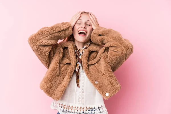 穿着粉色背景外套的年轻金发女人高兴地把手放在头上笑着 幸福的概念 — 图库照片