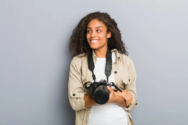 若いアフリカ系アメリカ人の写真家の女性は 腕を組んで自信を持って笑顔カメラを保持 — ストック写真