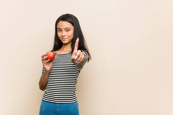 Młoda Azji Kobieta Trzyma Jabłko Pokazuje Numer Jeden Palec — Zdjęcie stockowe