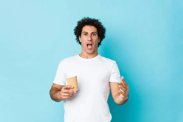 Jovem Caucasiano Encaracolado Homem Segurando Café Takeaway Comemorando Uma Vitória — Fotografia de Stock