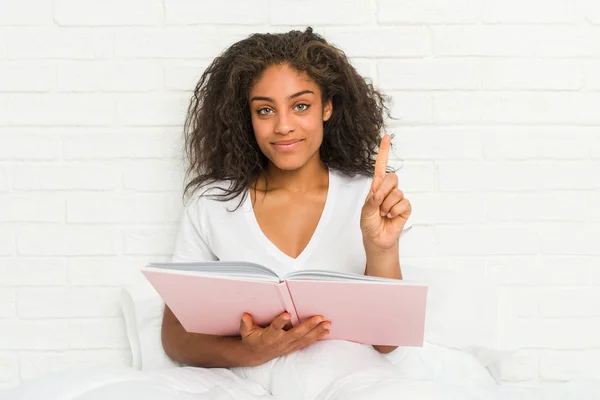 Jovem Afro Americana Sentada Cama Estudando Mostrando Número Com Dedo — Fotografia de Stock