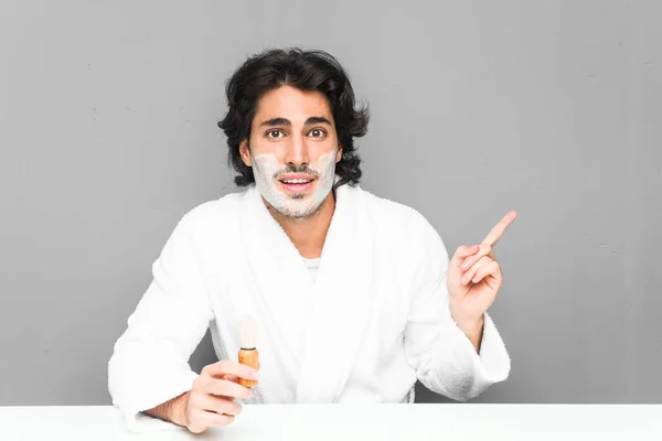 Young Man Shaving His Beard Smiling Cheerfully Pointing Forefinger Away — ストック写真