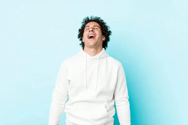 Junger Sportlicher Mann Vor Blauem Hintergrund Entspannt Und Glücklich Lachend — Stockfoto