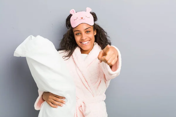 身穿睡衣 戴着睡眠面具 头戴枕头 面带微笑的年轻非洲裔美国女人 — 图库照片