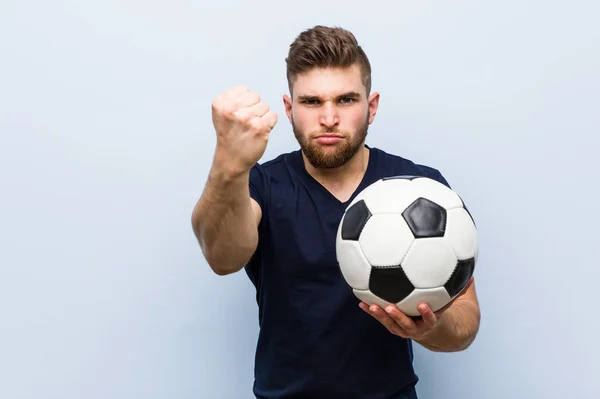 Jovem Caucasiano Segurando Uma Bola Futebol Mostrando Punho Para Câmera — Fotografia de Stock