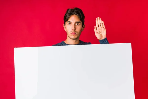 Νεαρός Άνδρας Κρατώντας Μια Πινακίδα Στέκεται Απλωμένο Χέρι Που Δείχνει — Φωτογραφία Αρχείου