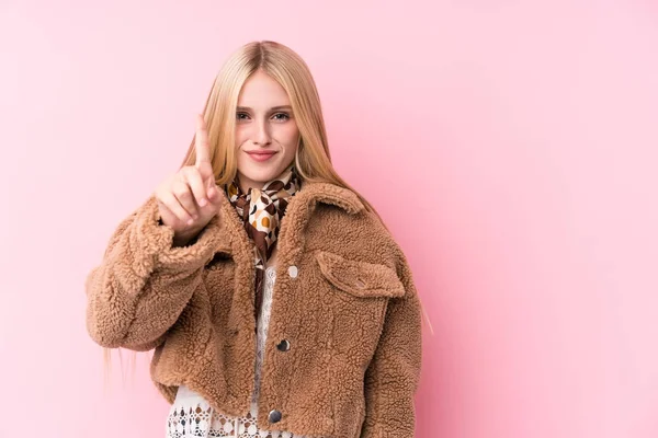 Ung Blond Kvinna Bär Rock Mot Rosa Bakgrund Visar Nummer — Stockfoto