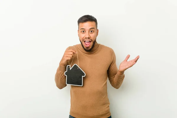 Young South Asian Man Holding Home Icon Celebrating Victory Success — Stock Photo, Image