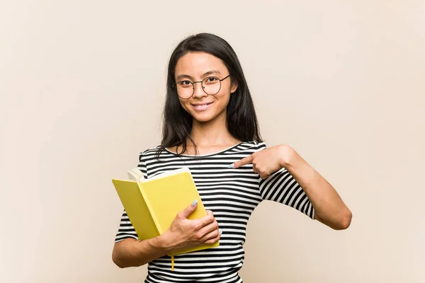 Νεαρή Ασιάτισσα Φοιτήτρια Που Κρατάει Έναν Βιβλιοπώλη Δείχνοντας Χέρι Χώρο — Φωτογραφία Αρχείου