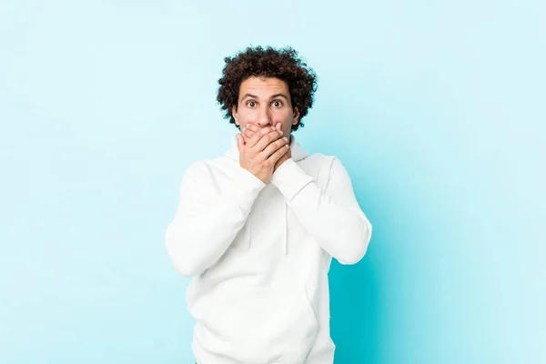 Jeune Homme Sportif Sur Fond Bleu Choqué Couvrant Bouche Avec — Photo