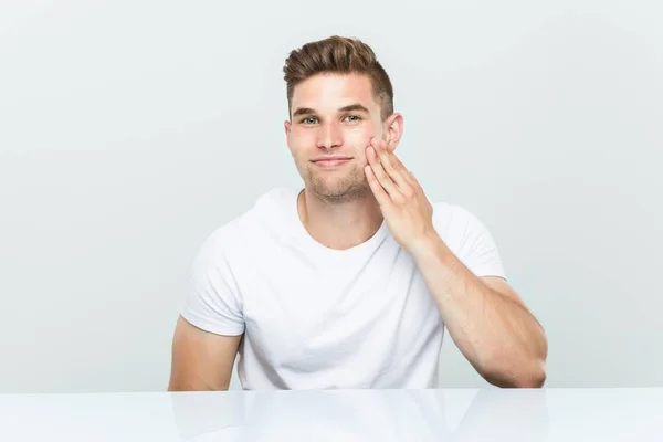 Young caucasian man using facial moisturizer — Stock Photo, Image