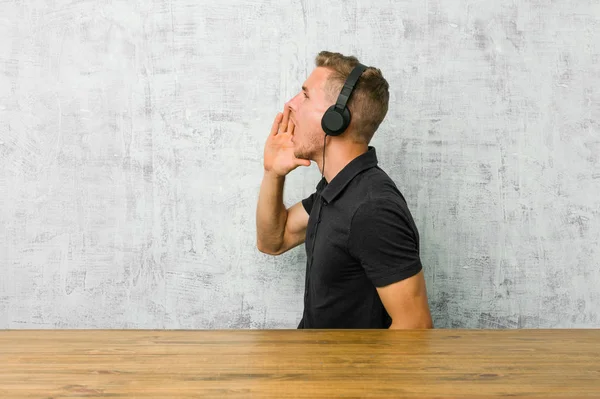 Young Caucasian Man Listening Music Headphones Shouting Holding Palm Opened — ストック写真