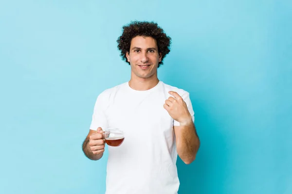 Homem Encaracolado Caucasiano Jovem Segurando Uma Xícara Chá Apontando Com — Fotografia de Stock