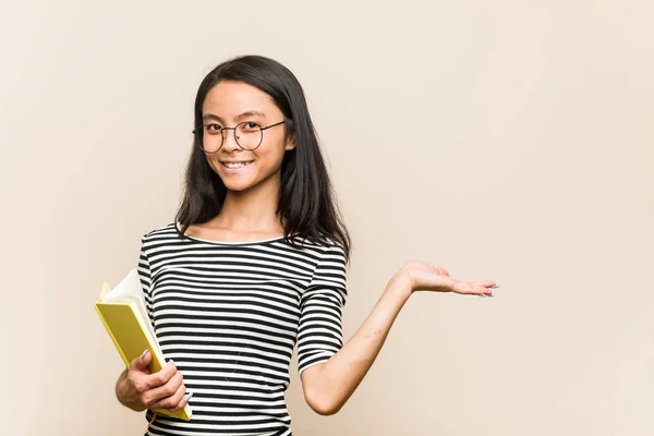 Νεαρή Ασιάτισσα Μαθήτρια Που Κρατάει Ένα Βιβλίο Που Δείχνει Ένα — Φωτογραφία Αρχείου