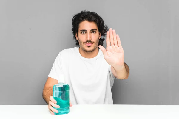 Young Man Holding Mouthwash Standing Outstretched Hand Showing Stop Sign — Stock Photo, Image