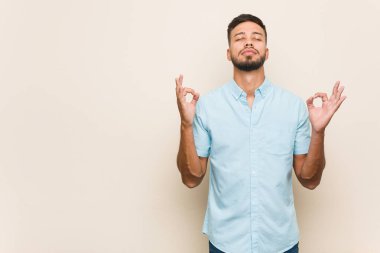 Genç Güney Asyalı adam sıkı çalışma gününden sonra rahatlıyor, o yoga yapıyor..