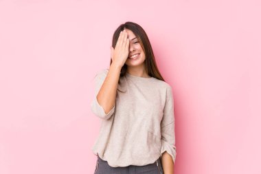 Kafkasyalı genç kadın yalnız poz veriyor. Yüzünün yarısını palmiyeyle kaplayarak eğleniyor..