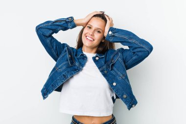 Genç ve tatlı bir kadın ellerini başının üstünde tutarak neşe içinde gülüyor. Mutluluk kavramı.