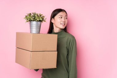 Kutuları saklayan genç Çinli kadın gülümseyen, neşeli ve keyifli bakışları bir yana bırak..