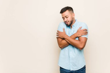 Güney Asyalı genç adam sarıldı, kaygısız ve mutlu gülümsedi..