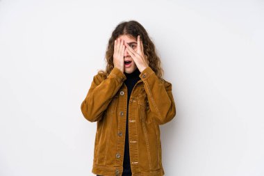 Uzun saçlı adam yalnız poz veriyor. Korkmuş ve gergin parmaklarıyla göz kırpıyor..