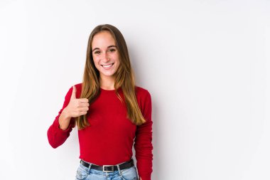 Kafkasyalı genç bir kadın yalnız poz veriyor gülümsüyor ve başparmağını kaldırıyor.