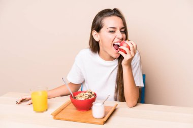 Genç beyaz kadın kahvaltı yapıyor.