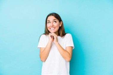 Kafkasyalı genç bir kadın yalnız, elleri çenesinin altında, mutlu bir şekilde yan tarafa bakıyor..