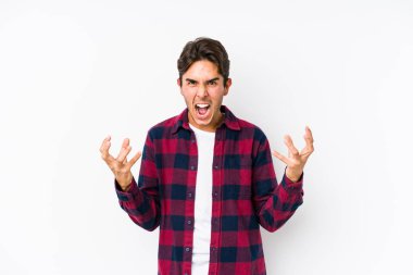 Pembe arka planda poz veren genç beyaz adam öfkeyle bağırıyor..