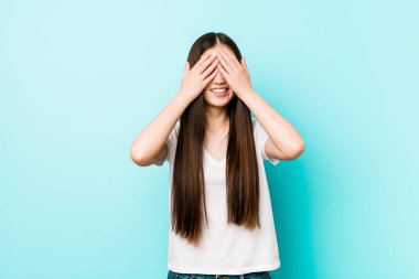 Genç, güzel Çinli kadın elleriyle gözlerini kapatıyor. Gülümsüyor ve bir sürpriz bekliyor..