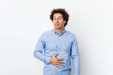 Zarif bir gömlek giyen kıvırcık, olgun bir genç göbeğe dokunur, nazikçe gülümser, yemek yer ve tatmin olur..