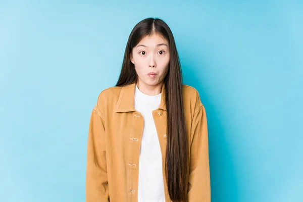 Young Chinese Woman Posing Blue Background Isolated Shrugs Shoulders Open — 스톡 사진