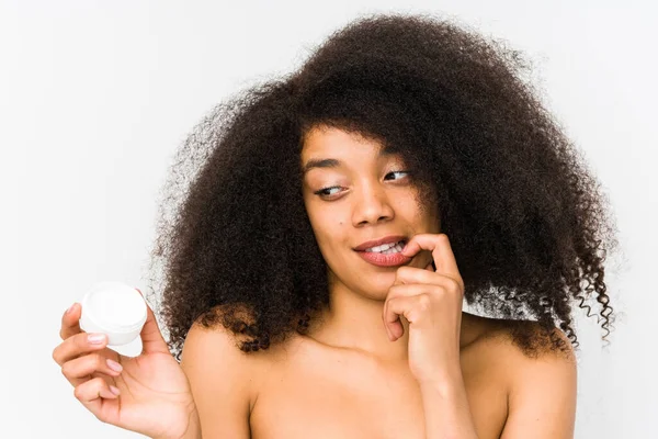 Mujer Afro Joven Sosteniendo Una Crema Hidratante Aislado Relajado Pensando — Foto de Stock