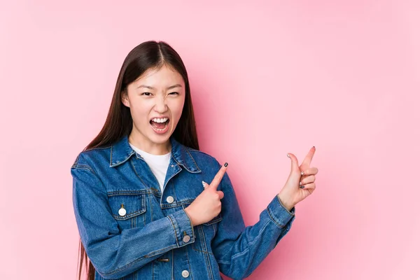 Young Chinese Woman Posing Pink Background Isolated Pointing Forefingers Copy — Stock Photo, Image