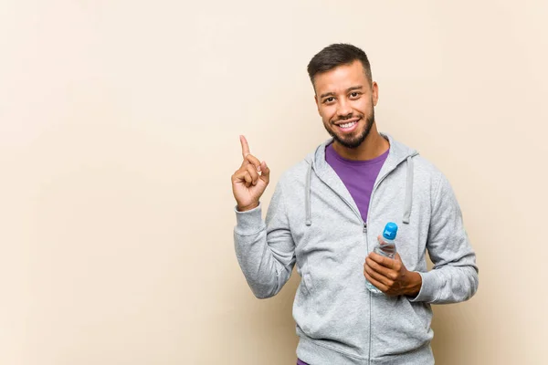 Joven Mixta Raza Asiático Hombre Sosteniendo Agua Botella Sonriendo Alegremente — Foto de Stock