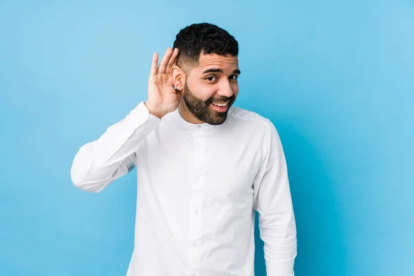 Joven Latino Sobre Fondo Azul Aislado Tratando Escuchar Chisme — Foto de Stock