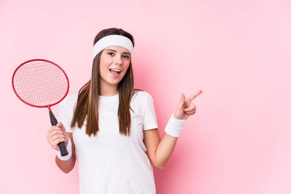 Ung Kaukasisk Kvinna Spelar Badminton Isolerad Ler Och Pekar Sidan — Stockfoto