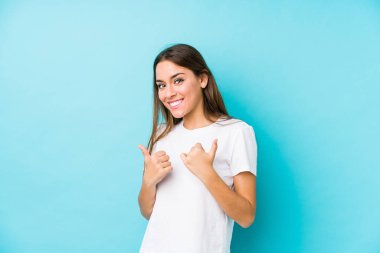 Kafkasyalı genç bir kadın kendini soyutlamış, iki parmağını da kaldırmış, gülümsüyor ve kendinden emin..