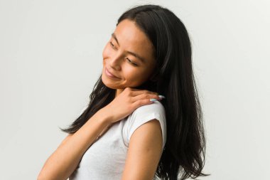 Beyaz arka planda poz veren genç Çinli kadın.